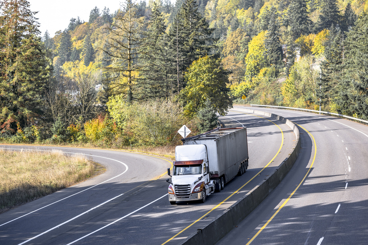 semtruck turning a curve on a highway - common causes of truck accidents