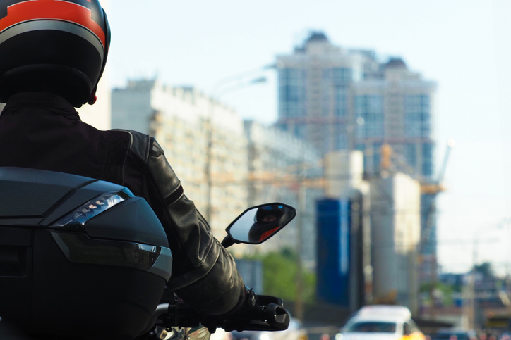 Back view of a motorcyclist riding in a city - what causes most motorcycle accidents?