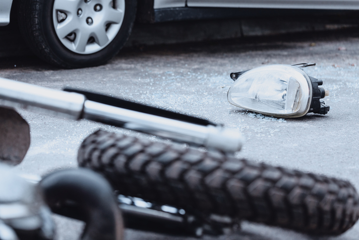 Broken car mirror and damaged motorcycle at a crash scene - what is the average settlement for a motorcycle accident in Georgia?